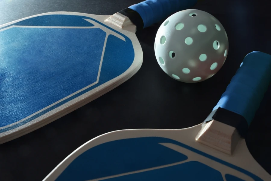 blue wood pickleball paddles and ball