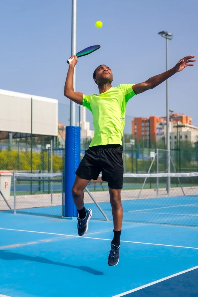 pickleball player hits a ball with paddle