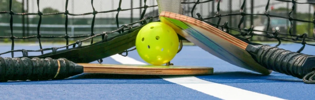 pickleball paddle and ball lay on the court