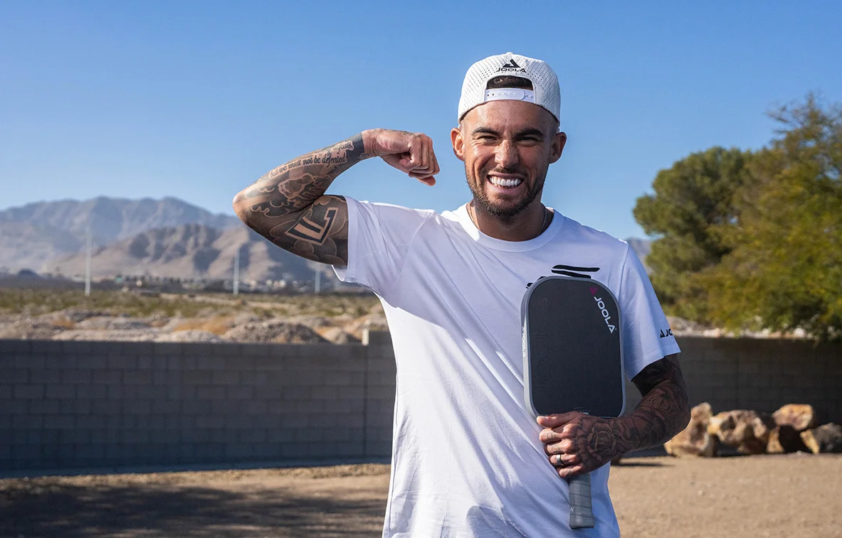 tyson mcguffin holds a long handle pickleball paddle from brand Joola