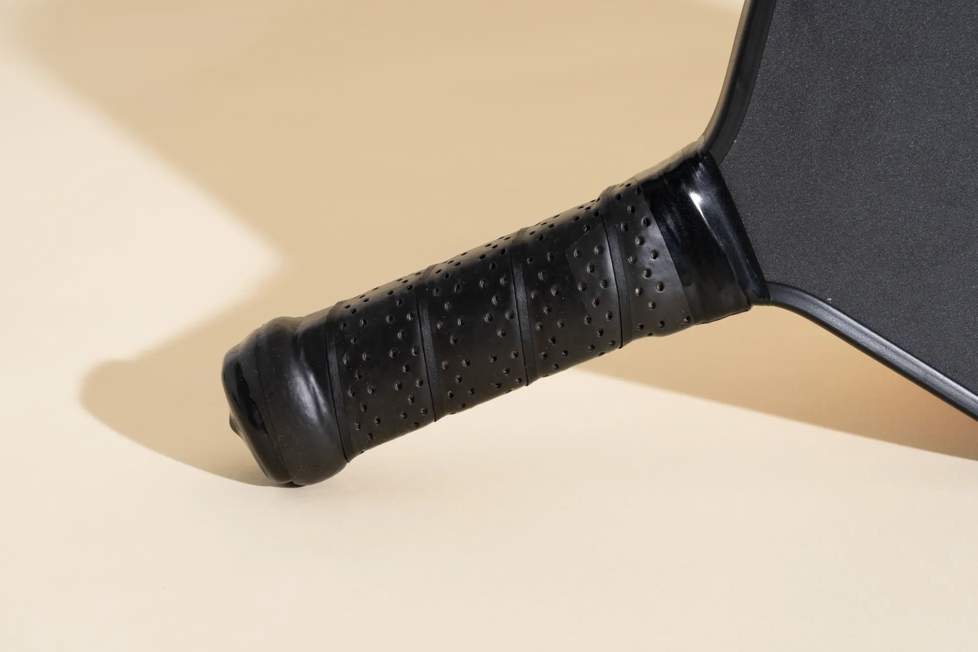 A close-up of the black rubber handle on the Paddletek Bantam EX-L pickleball paddle.