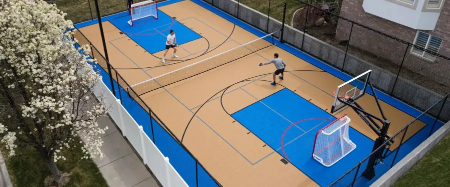 two man play pickleball on basketball court