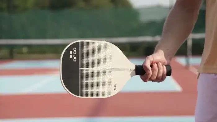 player holding a wood pickleball paddle