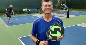 a man hold a donated pickleball paddle