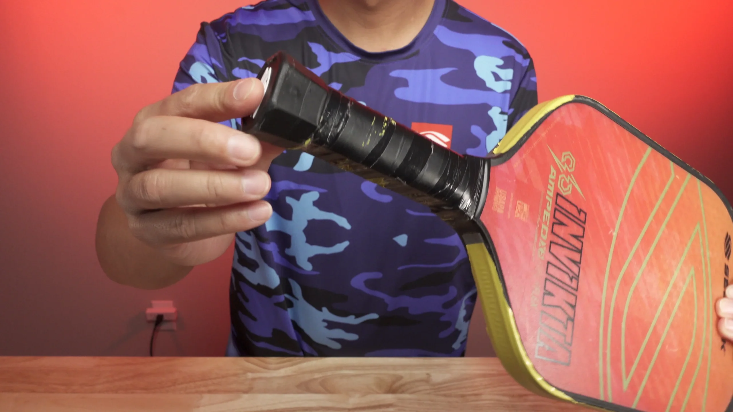 a man showing worn out grip of pickleball paddle