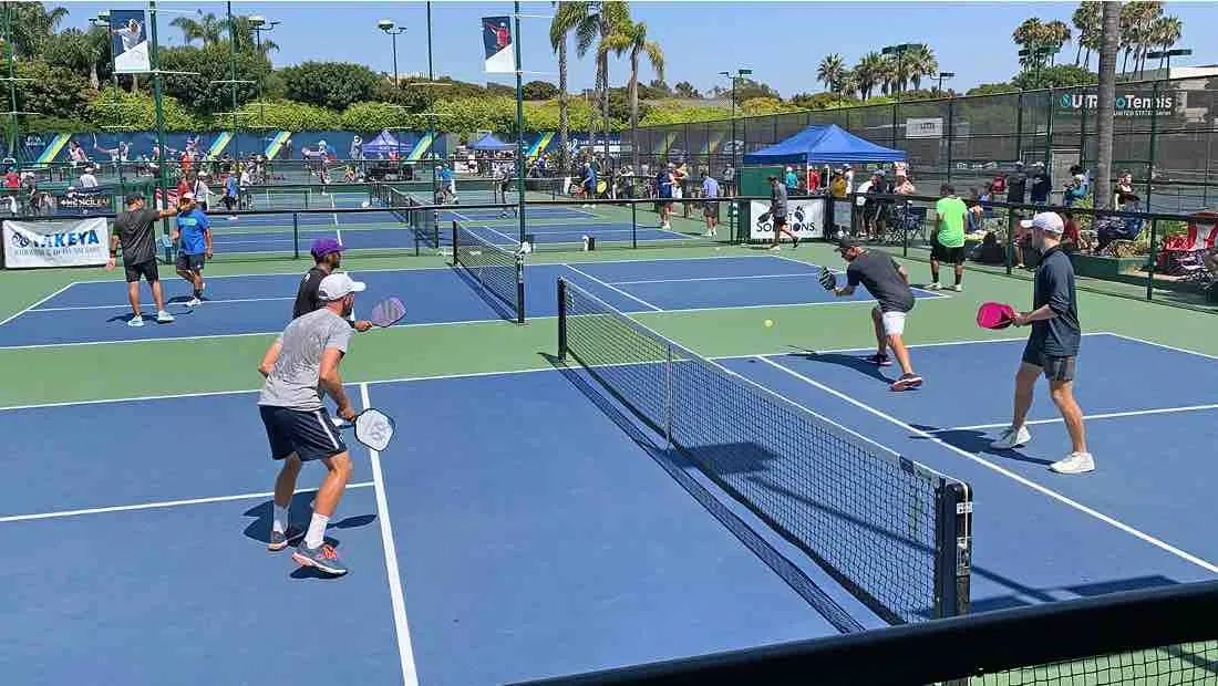 "Players strategically maneuver near the non-volley zone, keeping the rallies intense during a competitive doubles pickleball match.